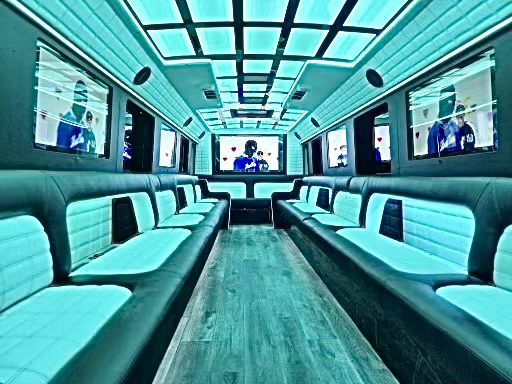 Party bus interior with teal LED lighting and white leather seating